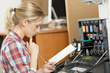 female technician fixing a printer