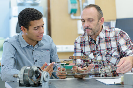 technician and apprentice analyzing a machine