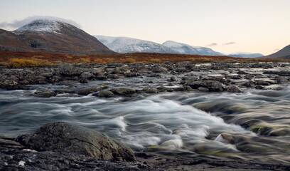 Beautiful Autumn Scenery in the Swedish Lapland with mountains and a river