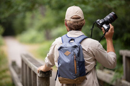 professional nature photographer on hike with his photography equipment