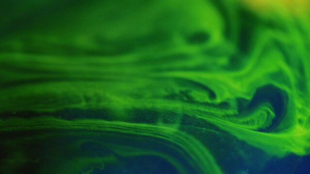 Neon mist. Paint water wave. Defocused glowing bright green blue color glitter smoke texture ink mix flow motion abstract art background.