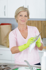 Naklejka na ściany i meble a senior woman washes plates
