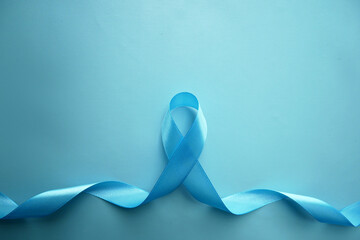 Blue awareness ribbon with the trail on a  blue background with copy space. Prostate Cancer Awareness, child abuse, diabetes.  - obrazy, fototapety, plakaty