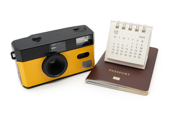 Obraz premium Simple desk calendar for December 2023 on Passport and Film Camera. Calendar and holiday concept with passport and camera isolate on white background.