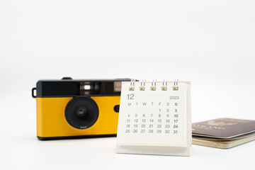Simple desk calendar for December 2023 and film camera. Calendar and holiday concept with copy space.