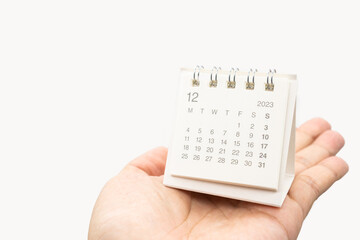 Simple desk calendar for December 2023 on palm isolated on white background. Calendar concept with copy space. - obrazy, fototapety, plakaty