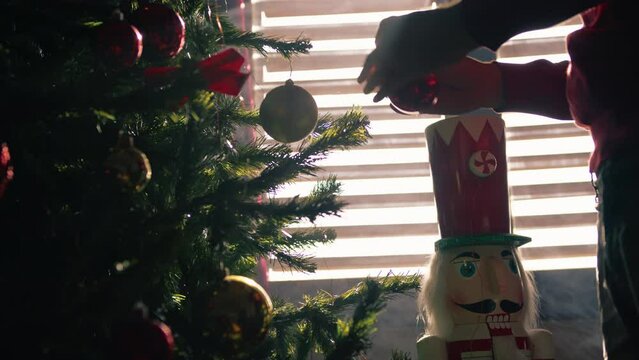 Hand decorating Christmas tree in silhouette