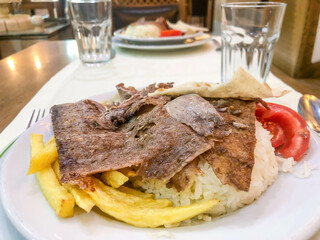 Traditional meat doner kebab on rice or turkish pilav on plate in turkey. 