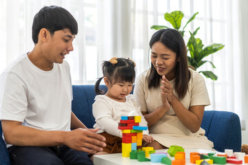 Obraz premium Portrait of enjoy happy love asian family father and mother with little asian girl smiling activity learn and skill brain play toy build wooden block board education game, children development at home