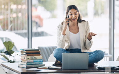 Obraz premium Worker, laptop and phone call and sitting on desk in relax startup, marketing company or advertising business. Smile, happy and talking woman on mobile communication technology, laptop or books study