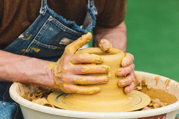 Clay craftsman sculpts crockery . Close-up.