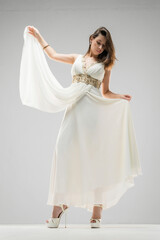 Obraz premium Woman in the retro style white dress posing on the white background.