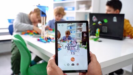 Quiver Augmented Reality for children game. Close up child hands hold digital tablet play with drawing 3d gadget screen in study classroom educational science - Powered by Adobe