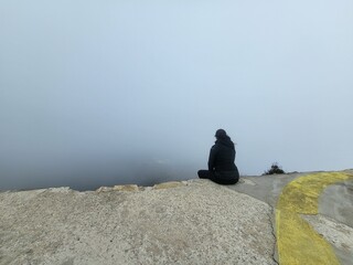 donna seduta su bordo nella nebbia