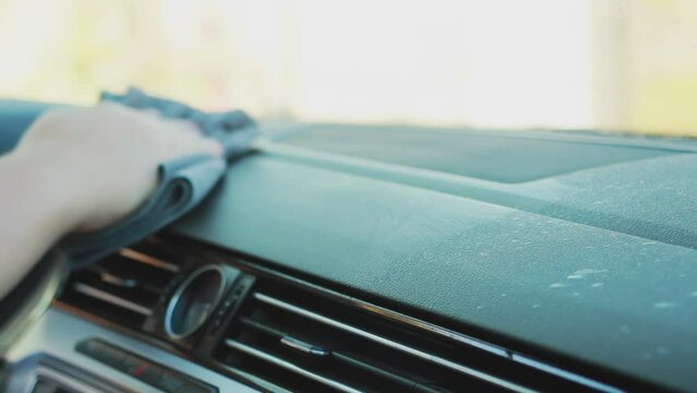 Wiping the plastic panel of the car with a rag with a restoring agent. Car interior care. Slow motion