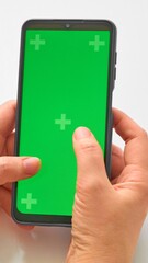 Elderly woman hands holding smartphone with green screen. Mock up mobile. The chromakey. Green screen