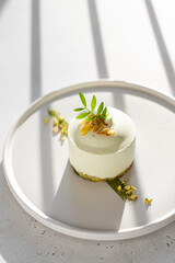 Vegan gluten free low calorie dessert. Round Pistachio mousse cake decorated with fresh pistachio...
