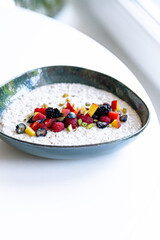 semolina porridge with berries in a plate on the white table