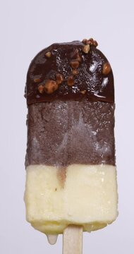 4K footage vertical video front view CU Time-lapse, Chocolate ice cream bars are melting on a white background.