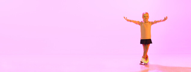 Beautiful adorable little girl, child in sweater and skirt6, training figure skating, dancing over pink background in neon light. Concept of childhood, figure skating sport, hobby, school, education