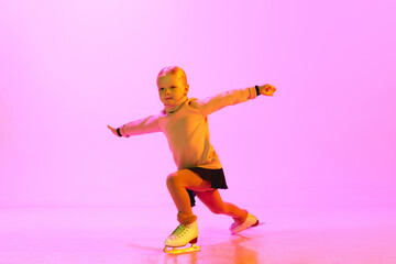 Little artistic, talented, adorable girl, child training figure skating, doing exercises against...