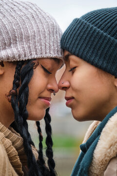 Dominican lesbian couple showing affection and love at street in a winter day.