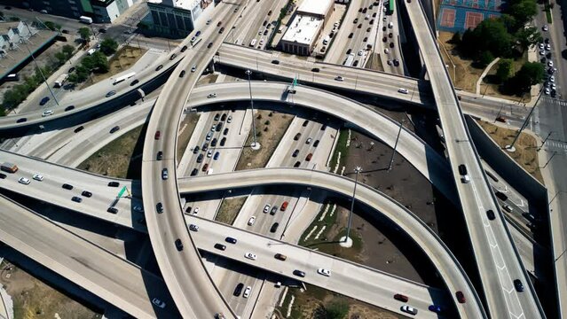 Overhead drone shot of cars driving over elevated highway and busy interchange in Chicago
