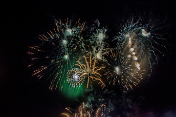Green and colorful fireworks burst into various shapes	
