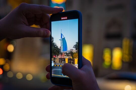 Young person taking a picture of buildings in Dubai