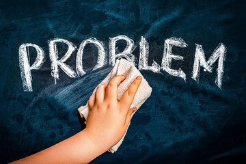 Problem solution metaphor. Hand wiping off chalk word PROBLEM on black chalkboard using rag. Remove...