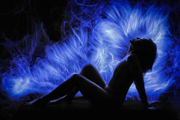 captivating silhouette of a nude figure enveloped in intricate blue light painting and fiber optic...