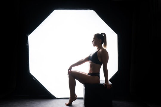 Silhouette of a beautiful young woman wearing underwear in backlight