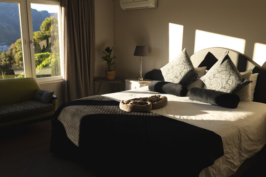 Interior of sunny domestic bedroom with double bed and mountain views, copy space