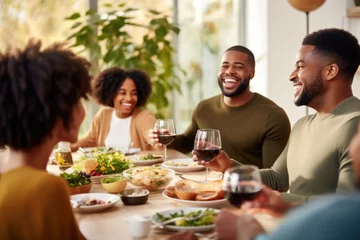 Zelfklevend Fotobehang African American family having dinner during thanksgiving day. Happy people celebrating holiday, eating and laughing together © Jasmina