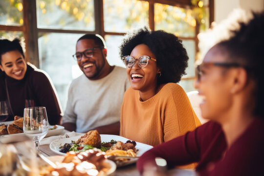 African American family having dinner during thanksgiving day. Happy people celebrating holiday, eating and laughing together