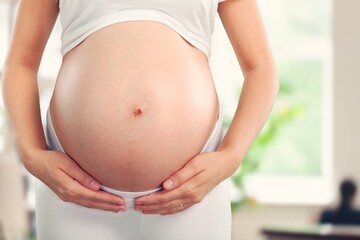 pregnant woman naked belly hold in hands