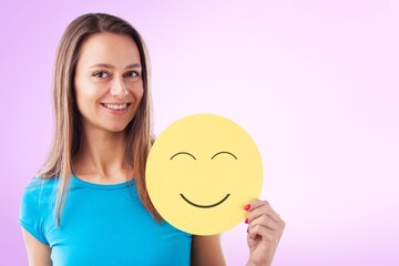 Happy teen girl holding emoji face