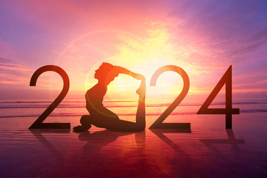Happy new year card 2024. Silhouette of healthy girl doing Yoga One Legged Pigeon pose on tropical beach with sunset sky background, woman practicing yoga as a part of the Number 2024 sign.