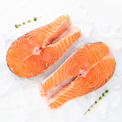 fresh salmon steaks sea fish peeled laid out on pieces of ice decorated sprig of greens isolated on white background top view for your design. healthy food. vitamins, omega b12 healthy fats for human