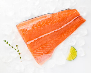 Salmon fillet sea fish peeled laid out on pieces of ice decorated with lemon sprig of greens isolated on white background top view for design. Healthy food. Vitamins, Omega B12 healthy fats