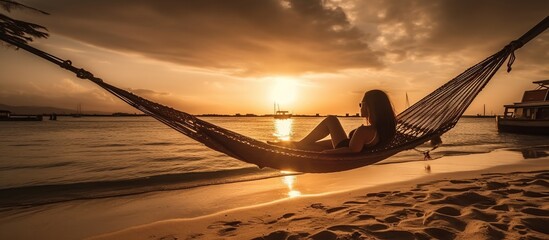 Woman relaxing in hammock on beautiful sunset beach