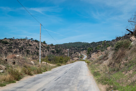 Entre montes uma estrada asfaltada com alguns postes de eletricidade a seguir a mesma em Trás os Montes, Portugal