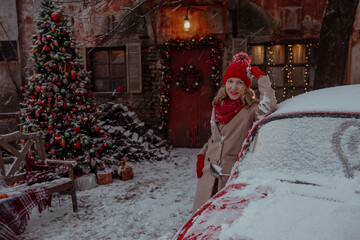 Woman in red outfit on christmas new year's eve with red car