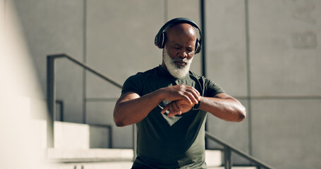 Fitness, headphones and black man on smart watch in city, workout progress and exercise results for...