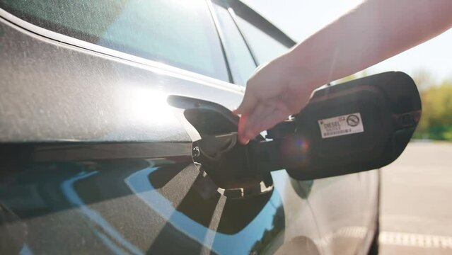 A man inserts an adapter into the fuel filler neck of a gas tank to refuel with diesel. Adapter for European standard, close-up. Slow motion