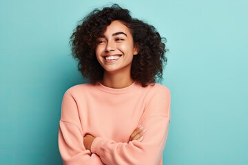 Fototapeta premium Portrait of a smiling young african american woman standing with arms crossed against blue background, ai generative
