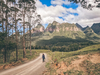 mulher caminhando em frente a montanhas de região conhecida como pirâmides sagradas em grão...