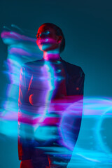 Silhouette of young woman standing against blue background with mixed neon lights effect. Hologram. Concept of modern art, beauty, style, futurism and cyberpunk, creativity