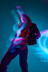 Young girl in casual clothes standing against blue background in neon lights. Mixed lights effect,...