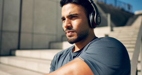 Fitness, music headphones and man on stairs in city, workout and exercise for body health. Radio,...